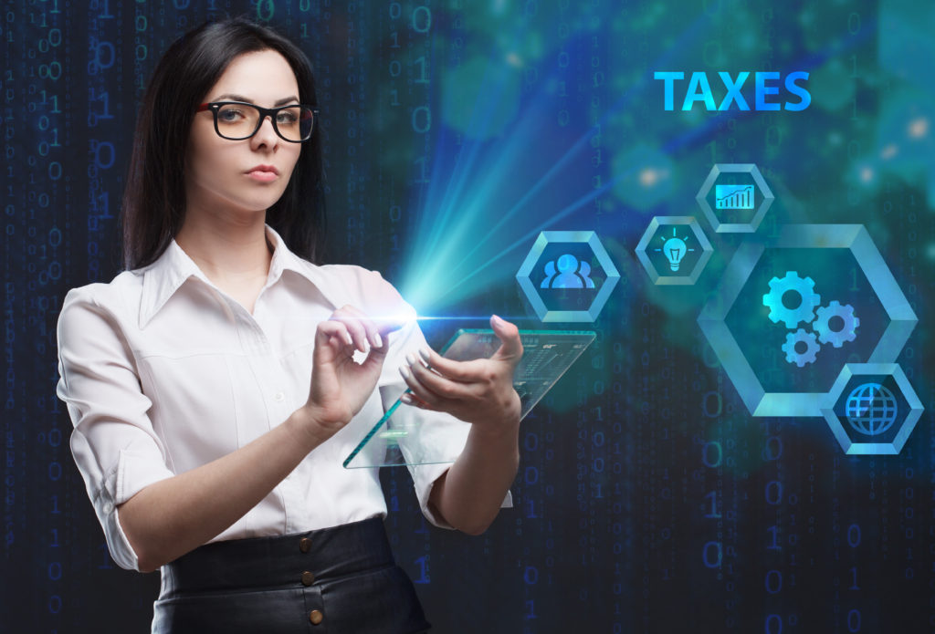 The concept of business, technology, the Internet and the network. A young entrepreneur working on a virtual screen of the future and sees the inscription: Taxes